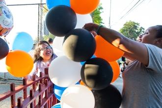 Two women work together to set up decorative balloons 