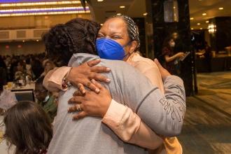 Two women embrace in a big hug