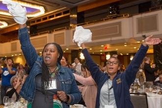 Two women raise their hands in support 