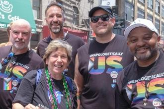 Members wearing matching shirts pose for a photo