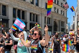 A group of marchers hold up pride flags 