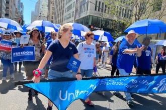 A group of union members march with UFT swag
