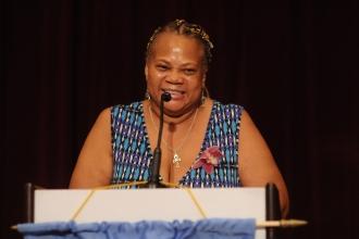 A woman speaks at the podium at the 2024 UFT Retired Teachers Chapter Luncheon