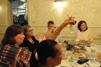 A group at a table raises their glasses in a toast