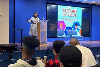 A woman speaks at a podium speaks to an audience.