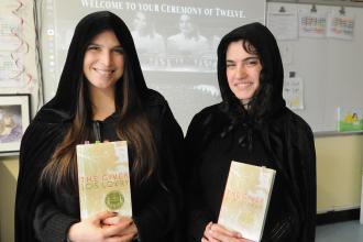  Cristina Cappiello and Arielle Schwartz,  co-teachers at MS 245 in Manhattan take a photo while wearing capes and holding a copy of "The Giver". 