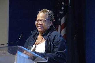 A woman speaks at the podium addressing her fellow nurses