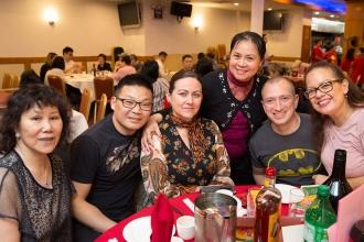 A group of union members celebrating Lunar New Year pose for a photo at a table.