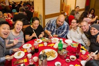 A table of members enjoys their meal with chopsticks. 