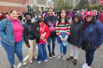 A group of marchers pose for a photo at a breast cancer awareness walk. 