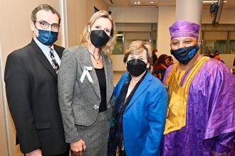 A group of members all wearing masks pose for a photo. 