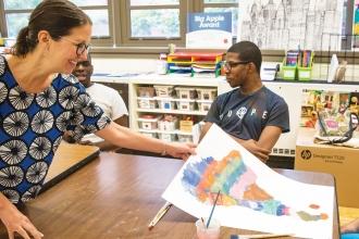 Art teacher Amie Robinson admires a student’s work