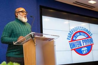 A man sings the national anthem at the podium