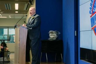 A man is standing at a podium speaking to an audience. 