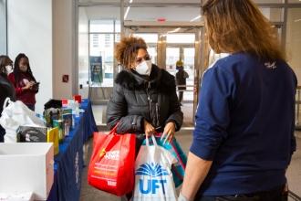 Two women engage in a conversation while wearing masks.