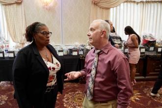 A man on the right talks to the woman on the left.