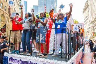 Members on the float raise their hands in joy. While traveling through the city. 