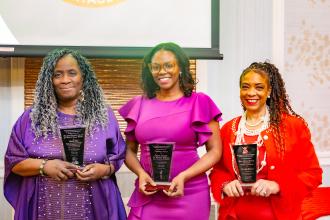 Award-winning teachers Mavis Yon (left) and Marilyn Brown (right) proudly hold their plaques alongside City Council Deputy Speaker Natasha Williams (center), who was presented the Trailblazer Award.