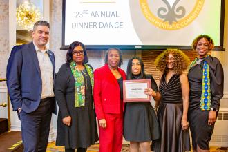 Standing with student scholarship winner Brooke Tindal (third from the right) are UFT Secretary Michael Sill, UFT African Heritage Committee co-Chair Wendy Walker Wilson, Alford, UFT District 16 Representative Camille Eaddy and UFT African Heritage Committee co-Chair Latoya Lebby.