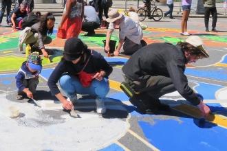 Youth drawing chalk art on ground in front of the White House