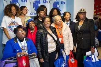Group of women smile in front of a camera