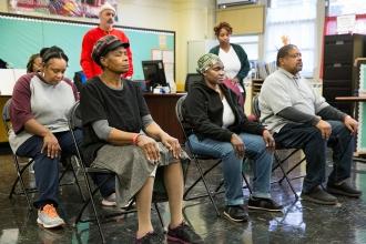 Seated group with eyes closed performing yoga