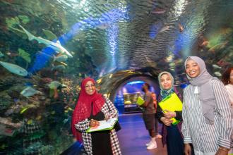 Three women visiting an aquarium.