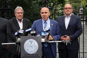 Three men wearing suits standing at a podium