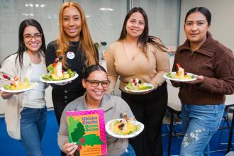 Members display the tropical fruit sculpture trees they built around the classic early reader “Chicka Chicka Boom Boom.”