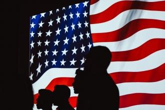 Silhouette of people with the American Flag as a backdrop