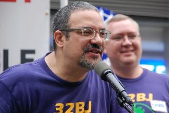 32BJ president Hector Figueroa leaning into microphone