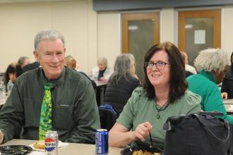 Members and attendees wear green in celebration of Irish American heritage.
