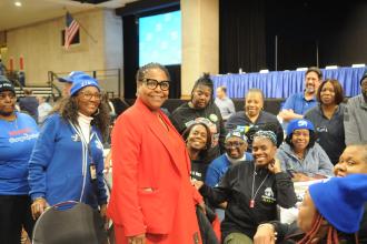 Members from District 16 in Brooklyn speak about union priorities with state Assembly Member Stefani Zinerman (standing, in red) in the Convention Center. 