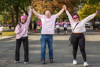 Three UFT members raise their arms in triumph during a Making Strides Against Breast Cancer walk on October 19 in Queens. 