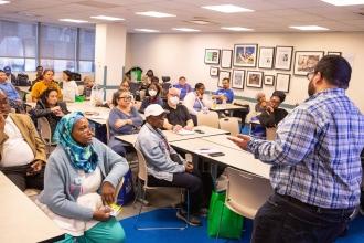 Attendees listen in as a speaker leads a workshop.