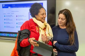 Teacher Stacey Davis (left) of IS 190 in the Bronx asks a question of UFT staffer Jeannie O’Connor following a workshop on “Understanding Your Paycheck” at the UFT 
