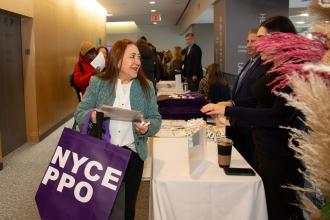 Reina Fiallos, a paraprofessional who retired in January from the Union Square Academy for Health Sciences in Manhattan, learns about health care options and retiree programs at the vendor fair before the luncheon.