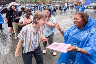 Paige Davis (left), who will teach at PS 36 in Manhattan, gets help signing up for the union