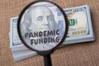 Image of a magnifying glass with the words pandemic funding