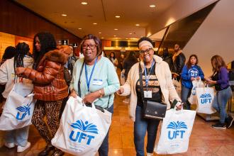 Shirley Cumberbatch (right) and Natasha Honore, paraprofessionals at PS 181 in Brooklyn, collect their wellness bags from the resource fair at the UFT Paraprofessional Awards Luncheon on March 7, 2026.