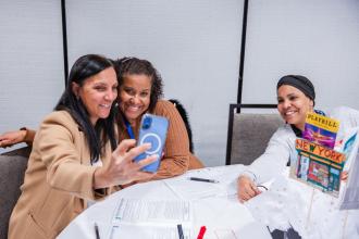 Snapping a selfie after a workshop titled “From Bodegas to Broadway: Poetic Voices from the Five Boroughs” are (from left) paraprofessionals Maely Araujo of PS 50 in Queens, Izabel Alves of PS 152 in the Bronx and Alfida Morel of PS 28 in Manhattan.