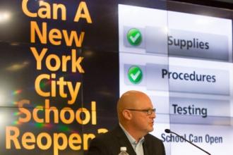 UFT President Michael Mulgrew sitting at podium