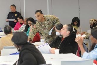 Army National Guard Staff Sergeant hands out certificates at the end of a workshop. 