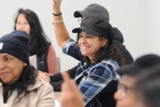 A woman smiles while listening to a workshop
