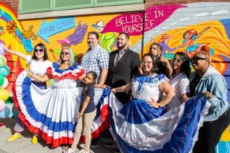  PS 18 art teacher Zoila Cordova (third from right), who serves on the school’s United Community Schools Advisory Board, and UFT Paraprofessional Representative Norma Ortega (second from left) wear festive dress honoring Hispanic Heritage Month. 