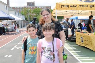 A Staten Island parent smiles for a photo with her two children at the UFT's 5th annual Staten Island Back-to-School BBQ.