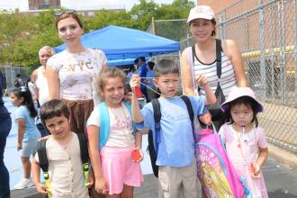 Staten Island students wear the new backpacks and other goodies they received at the event.