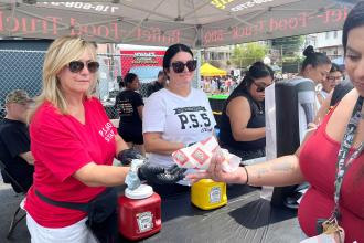Parent coordinators from Staten Island’s PS 60 and PS 5, respectively, hand out hot dogs at one of the food tents.