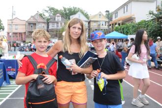 A Staten Island parent smiles for a photo with her two children at the UFT's 5th annual Staten Island Back-to-School BBQ.