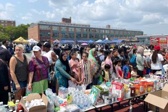 Staten Island families check out a giveaway table of food and supplies at the 5th annual Staten Island Back-to-School BBQ.
